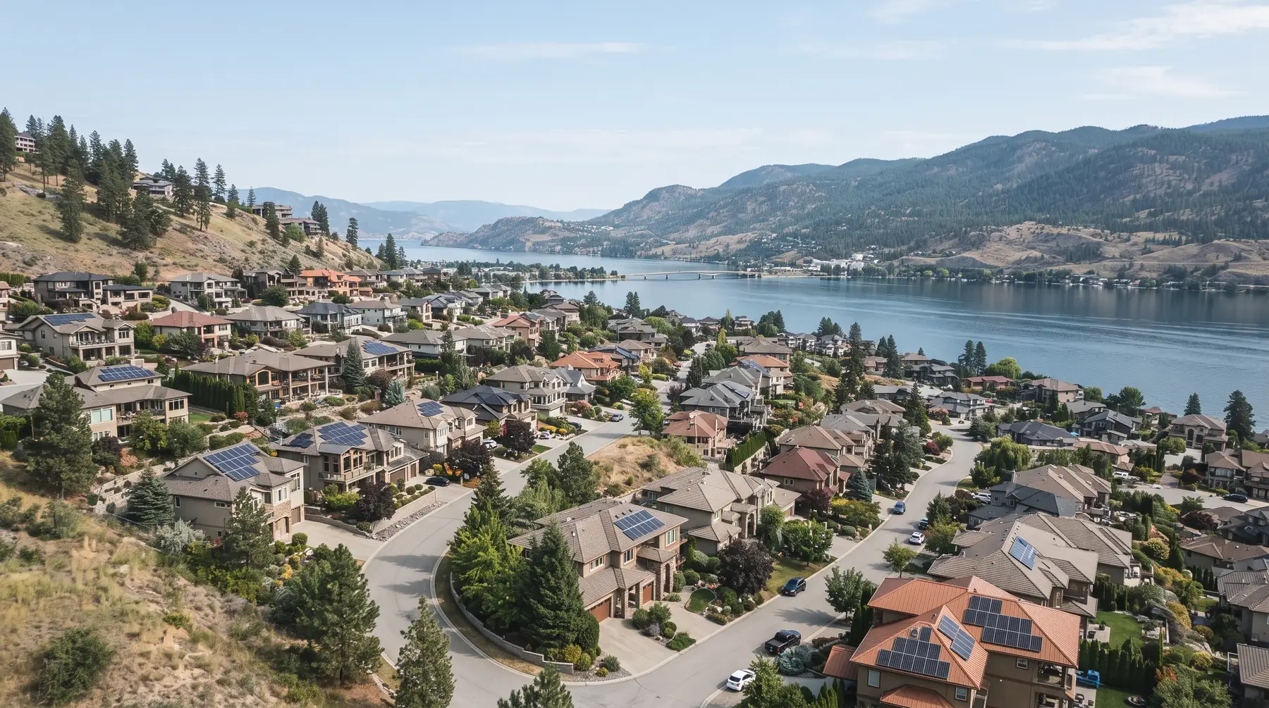 Hillside West Kelowna neighbourhood with rooftop solar stepping down to Okanagan Lake, near Rose Valley